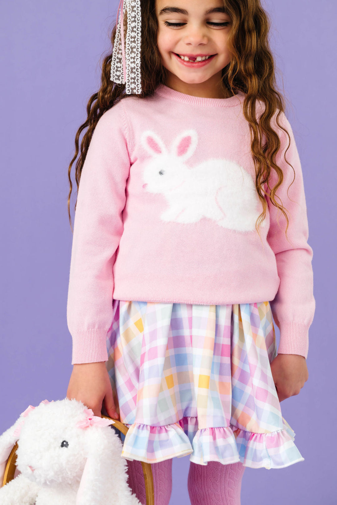 little girl holding bunny in pink knit bunny sweater paired with gingham twirl dress in pastel colors