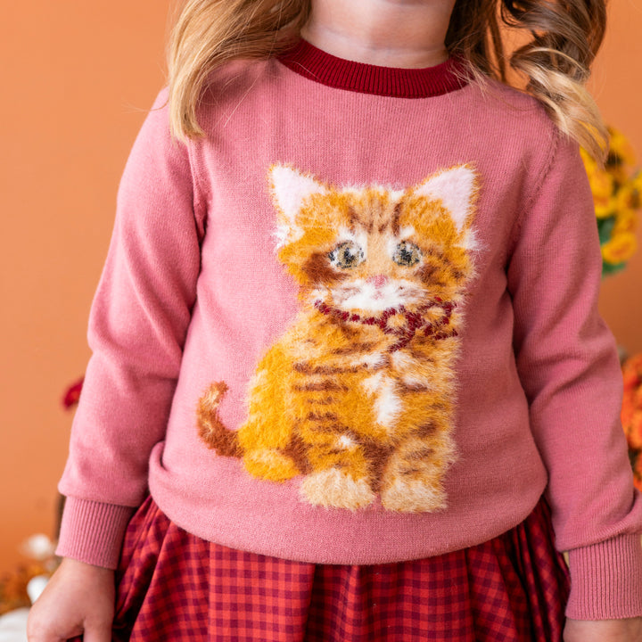 little girl in mauve cotton knit pullover sweater with fluffy yarn kitten design and burgundy trim at the neckline paired with rust and burgundy gingham dress