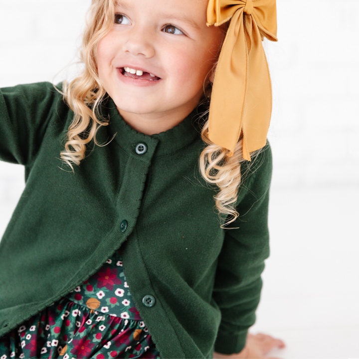 girl in dark green cardigan sweater with scallop edge detail