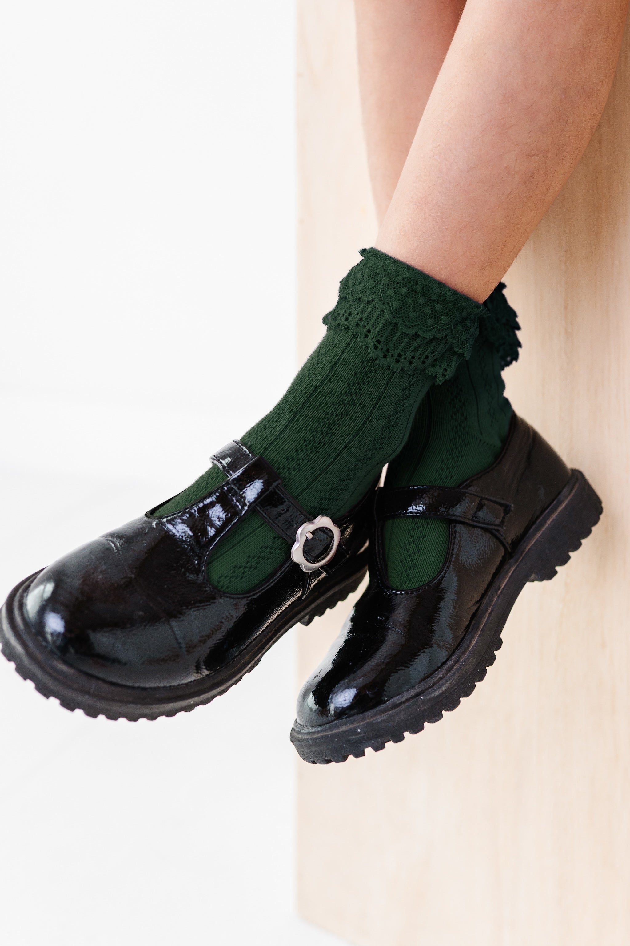 girl wearing forest green ankle socks with delicate lace trim, perfect for Christmas and special occasions and black patent mary jane shoes