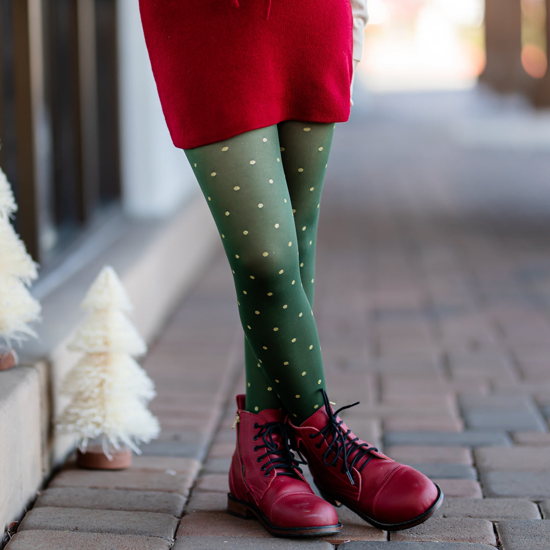 little girl in forest green nylon tights with gold glittery dots and crimson knit skirt