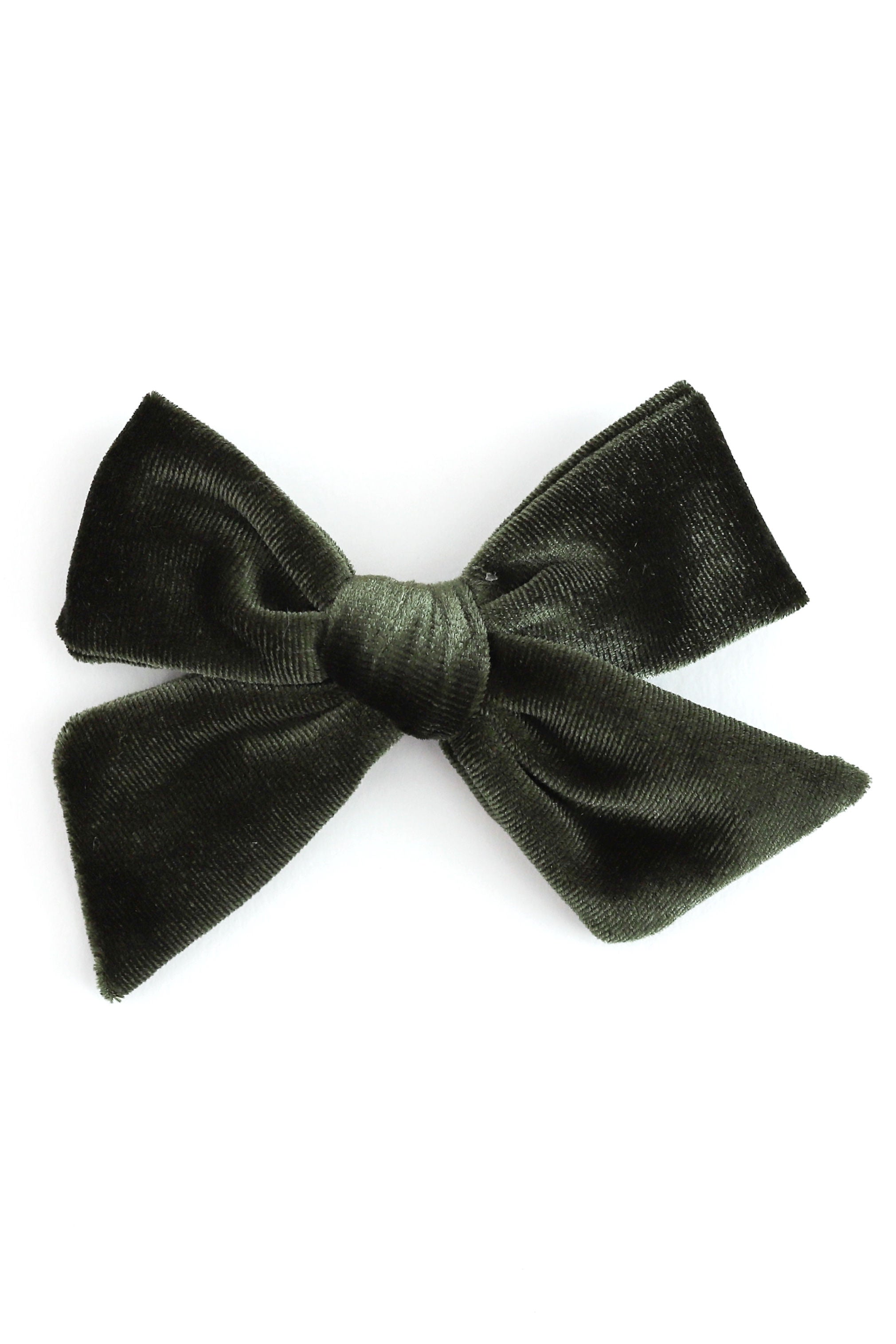 A dark green velvet hair bow clip photographed against a solid white background.