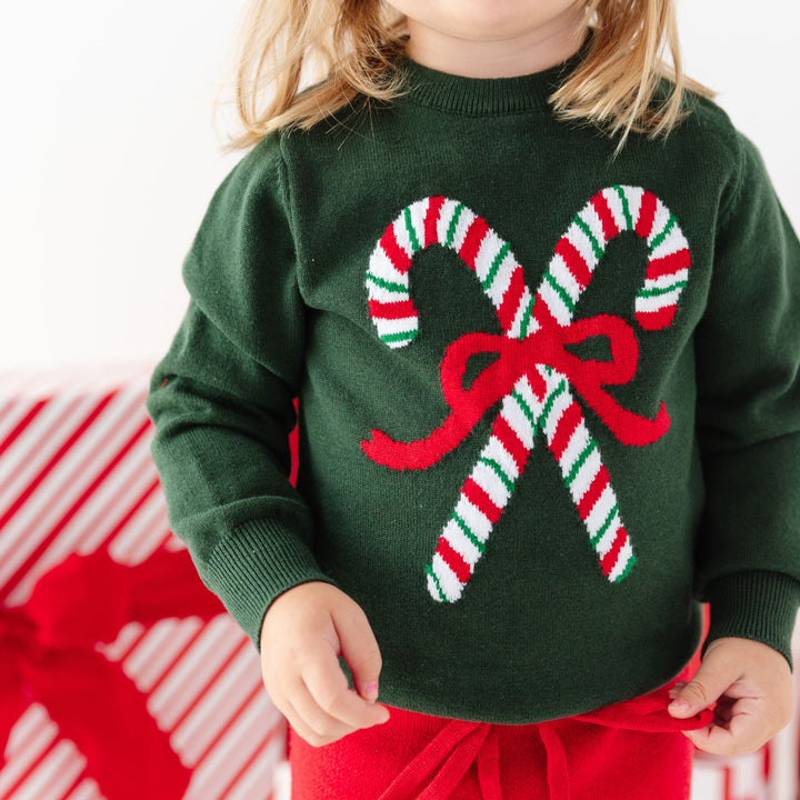 forest green knit sweater with candy canes and red bow