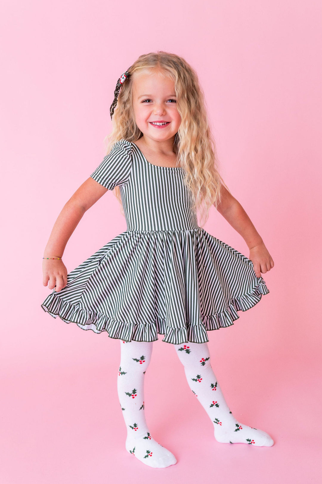 girl wearing green candy stripe dress with holly cotton tights