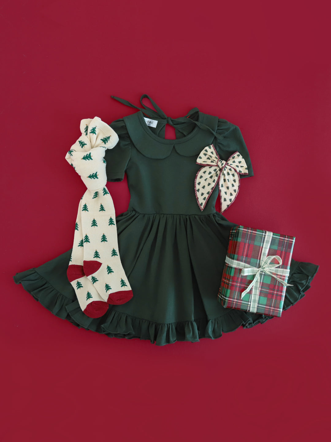 girls' Christmas outfit with forest green collared twirl dress paired with Christmas tree print tights and hair bow