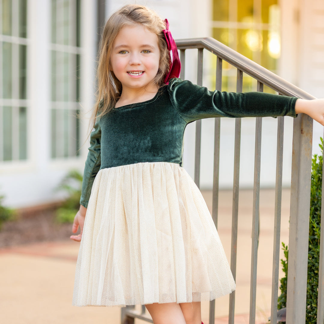 girl in forest green velvet long sleeve dress with cream tulle skirt and matching Christmas tree knee highs for Christmas party
