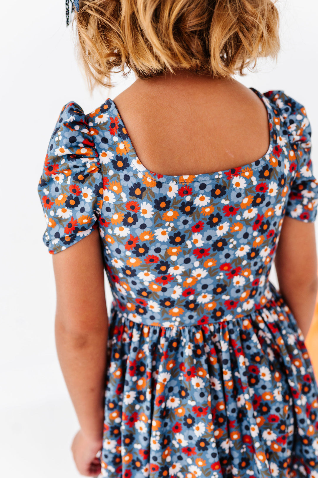 back detail of square neckline blue floral dress on little girl