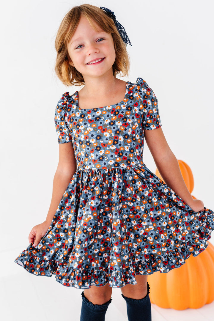 girl wearing blue floral fall twirl dress with navy knee high socks