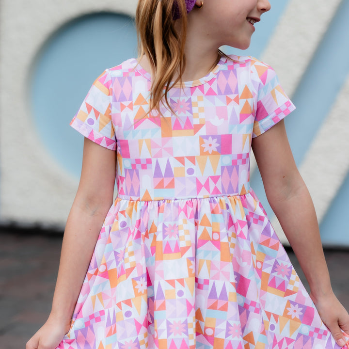 little girl wearing twirl dress in small world inspired geometric desgin