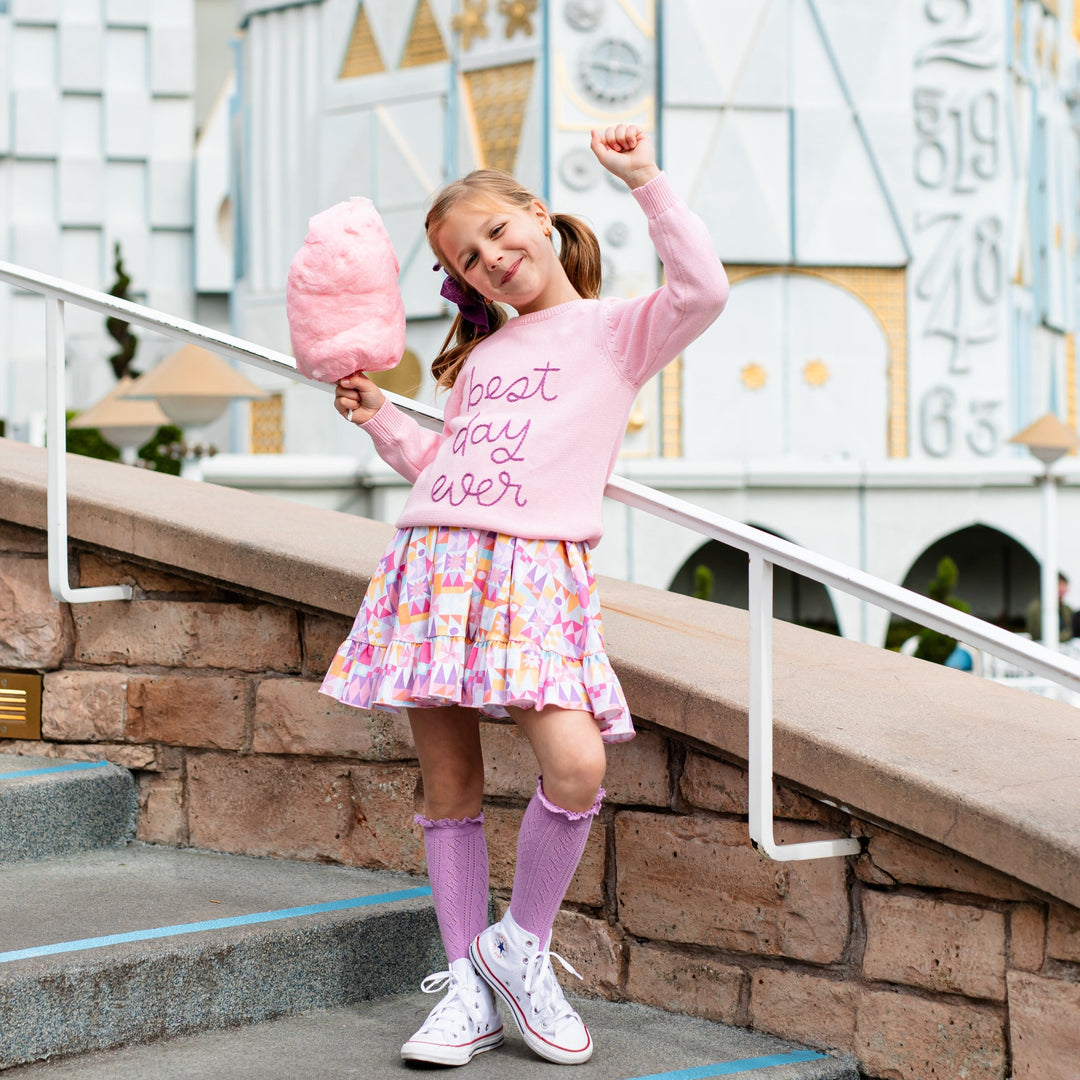 little girl wearing best day ever sweater at small world disneyland