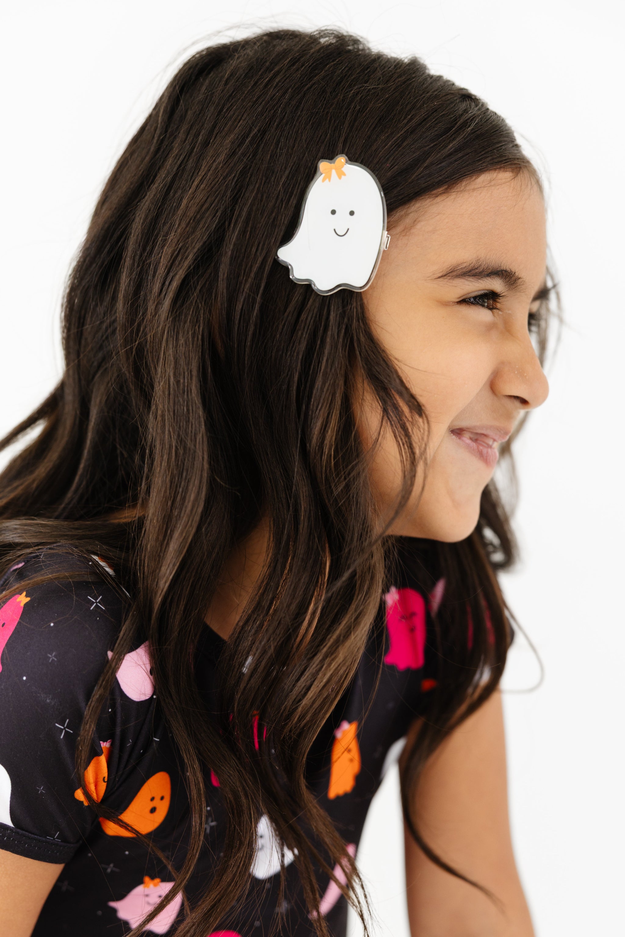 little girl in white acrylic ghost clip with orange bow detail and matching ghost print top