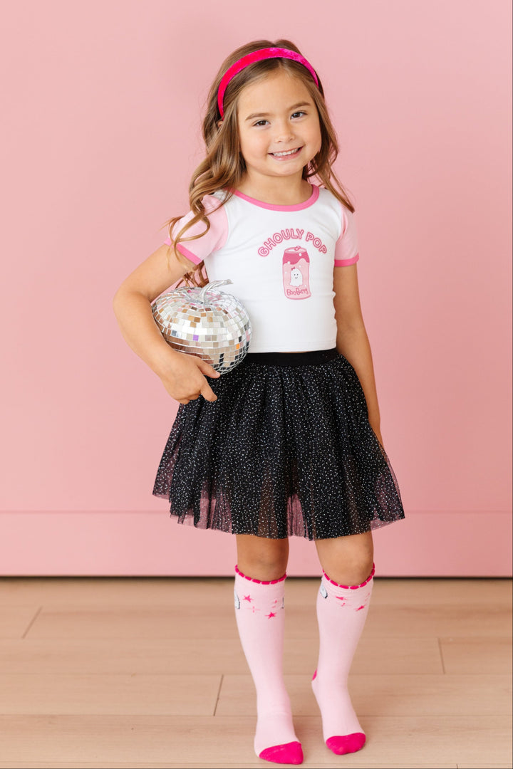 little girl in pink Halloween outfit with  Ghouly Pop top, matching pink ghost knees socks, pink velvet headband and black sparkle tutu skort