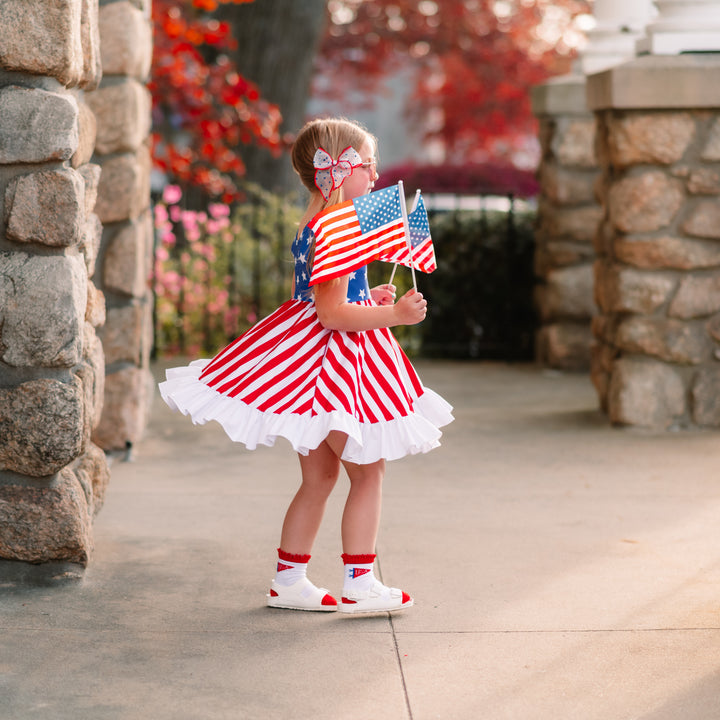 little girl twirling in american flag dress