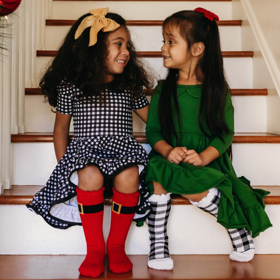 little girls wearing christmas twirl dresses with christmas knee high socks