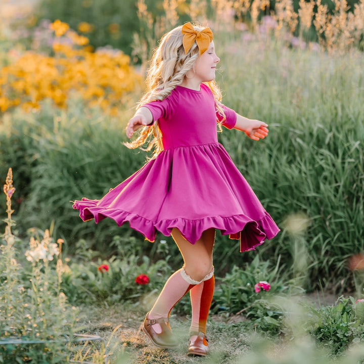 little girl wearing magenta twirl dress for family photos