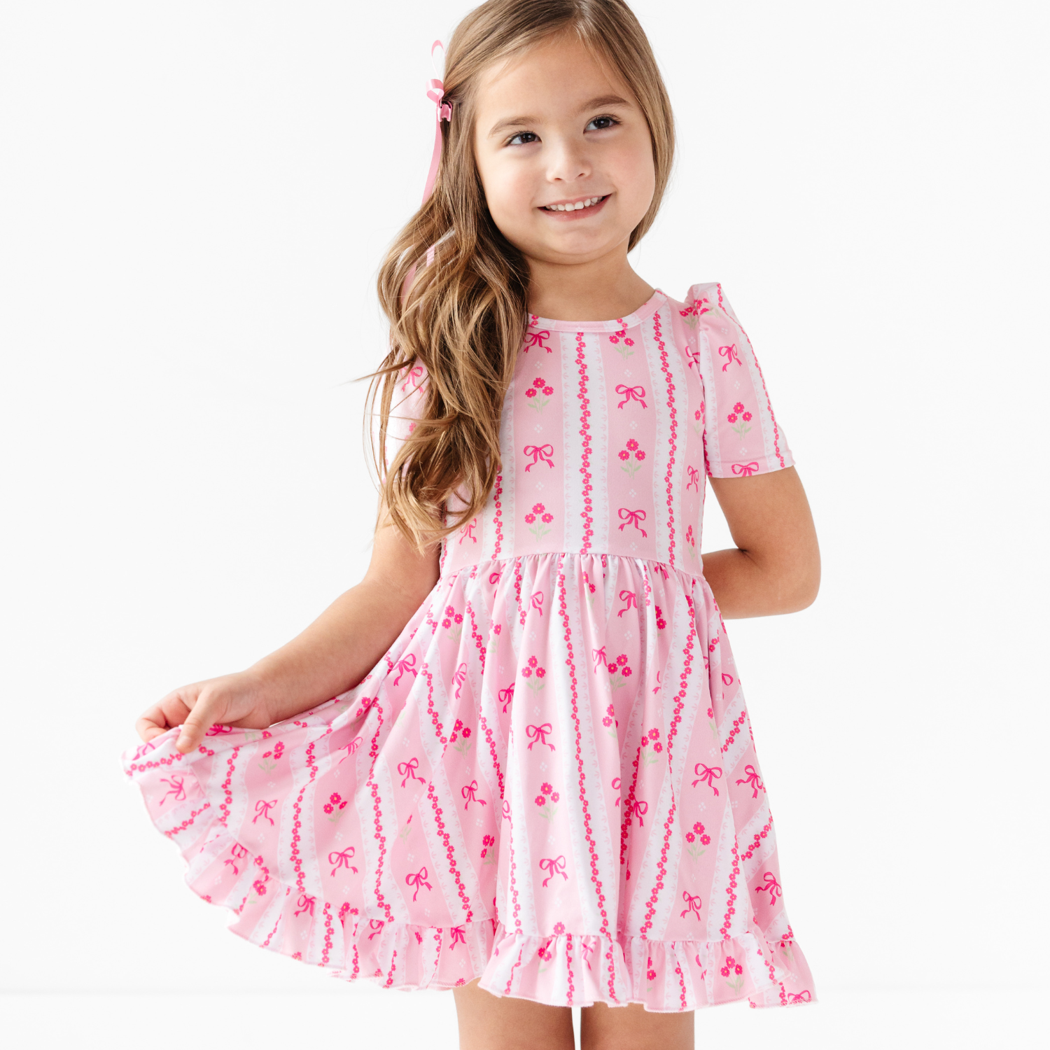 girl wearing white and pink wallpaper print dress with bows and flowers