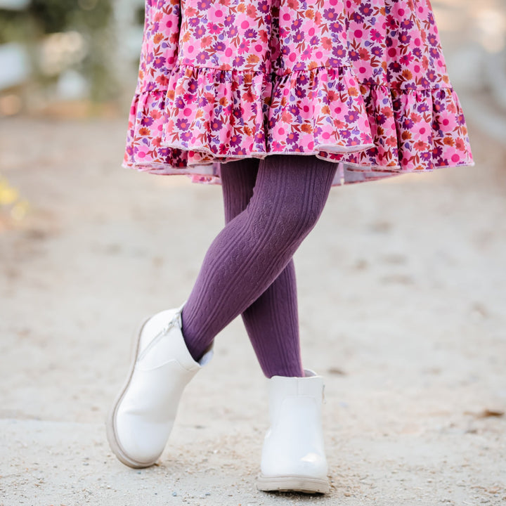 little girl wearing pink fall floral twirl dress and purple cable knit tights