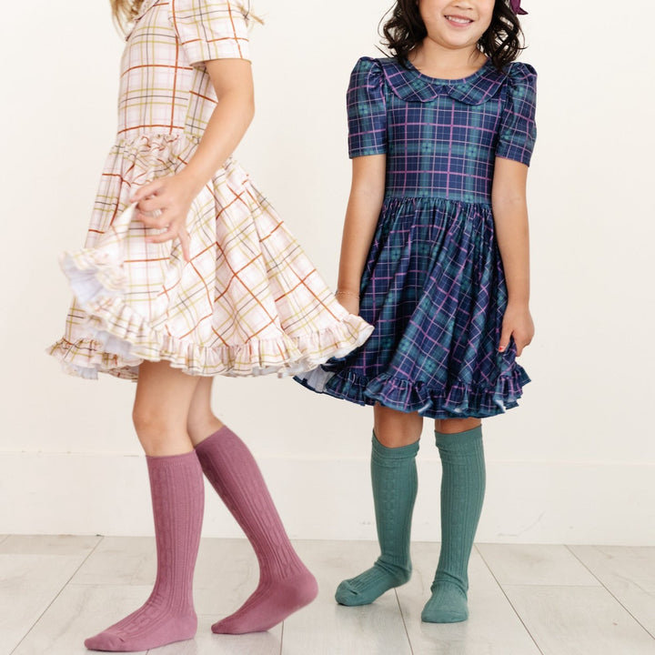 girls wearing plaid twirl dresses with matching knee high socks