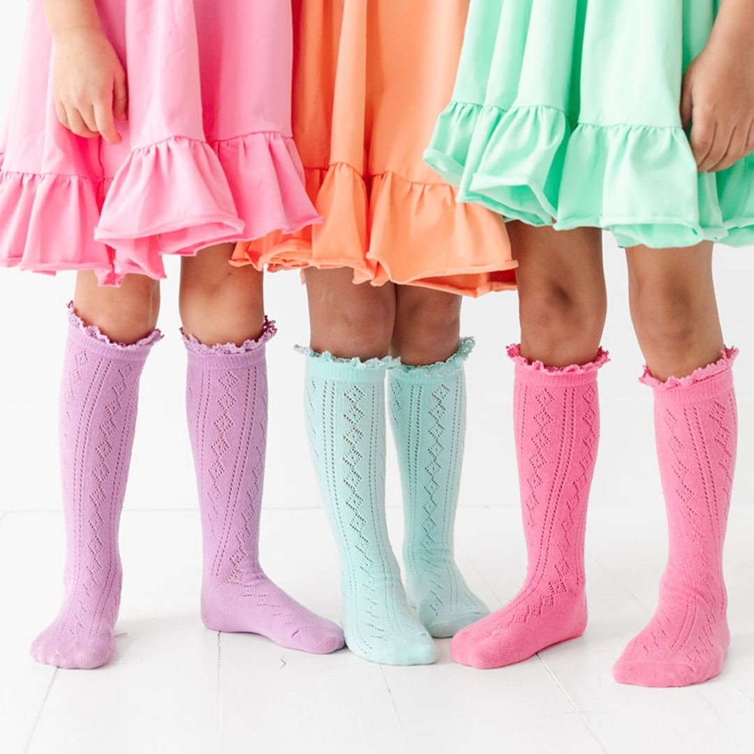 three girls standing together in fancy open knit crochet style vintage knee high socks with lace