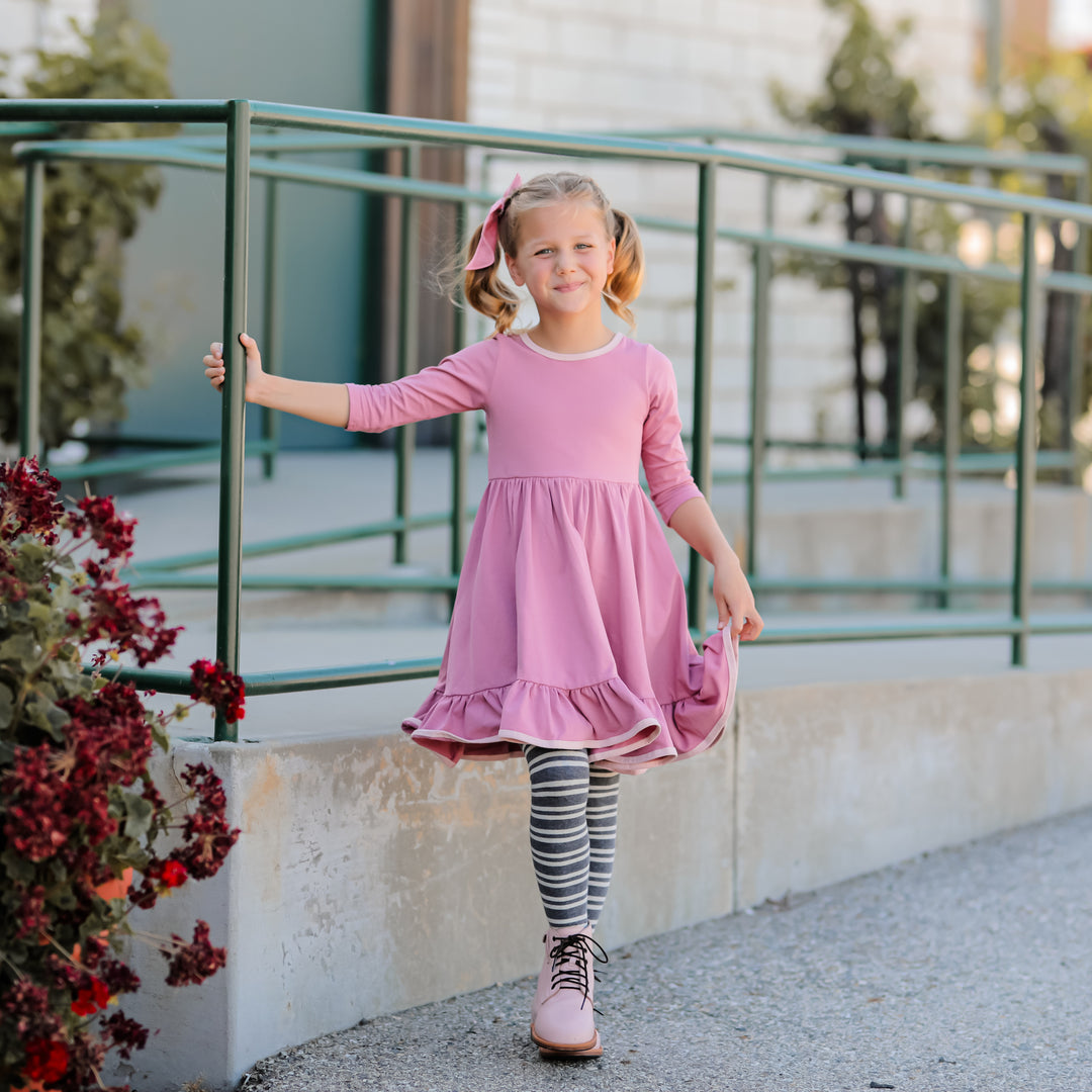 little girl wearing gray striped knit tights under dusty pink twirl dress