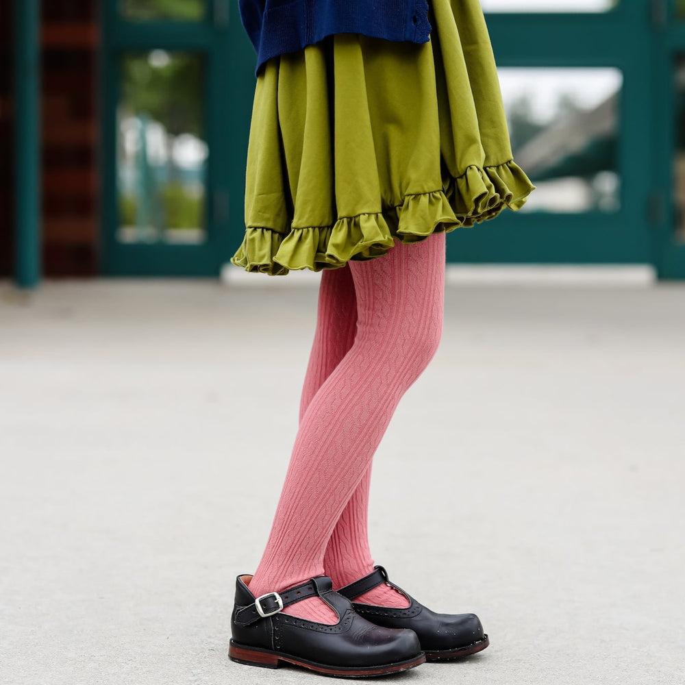 rose pink cable knit tights on girl wearing olive green twirl dress and black shoes