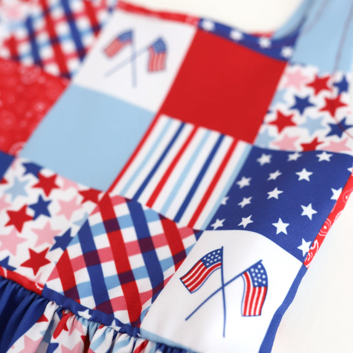 close up of girls' patchwork print twirl dress with multiple patterns and American flags in red, white and blue for the 4th of July