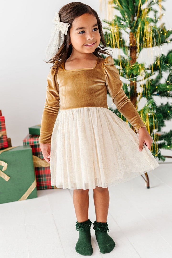little girl wearing gold velvet christmas dress with forest green lace bobby socks
