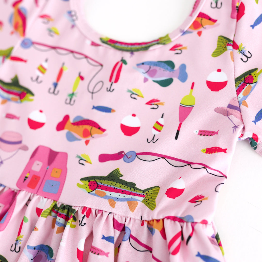 close up of girls' pink twirl dress bodice with colorful fish and fishing gear