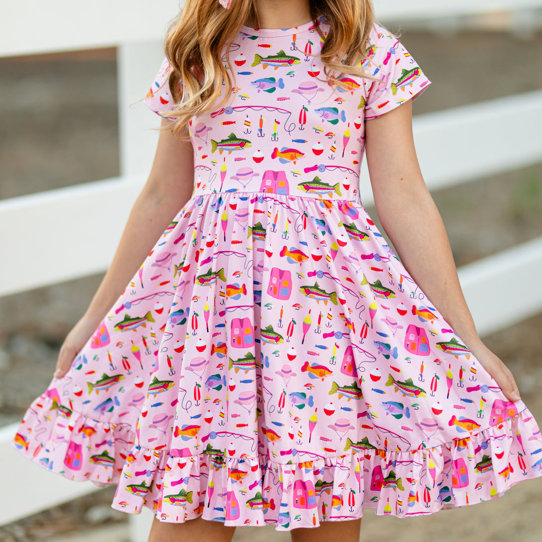 girl in pink short sleeve twirl dress with fishing themed print