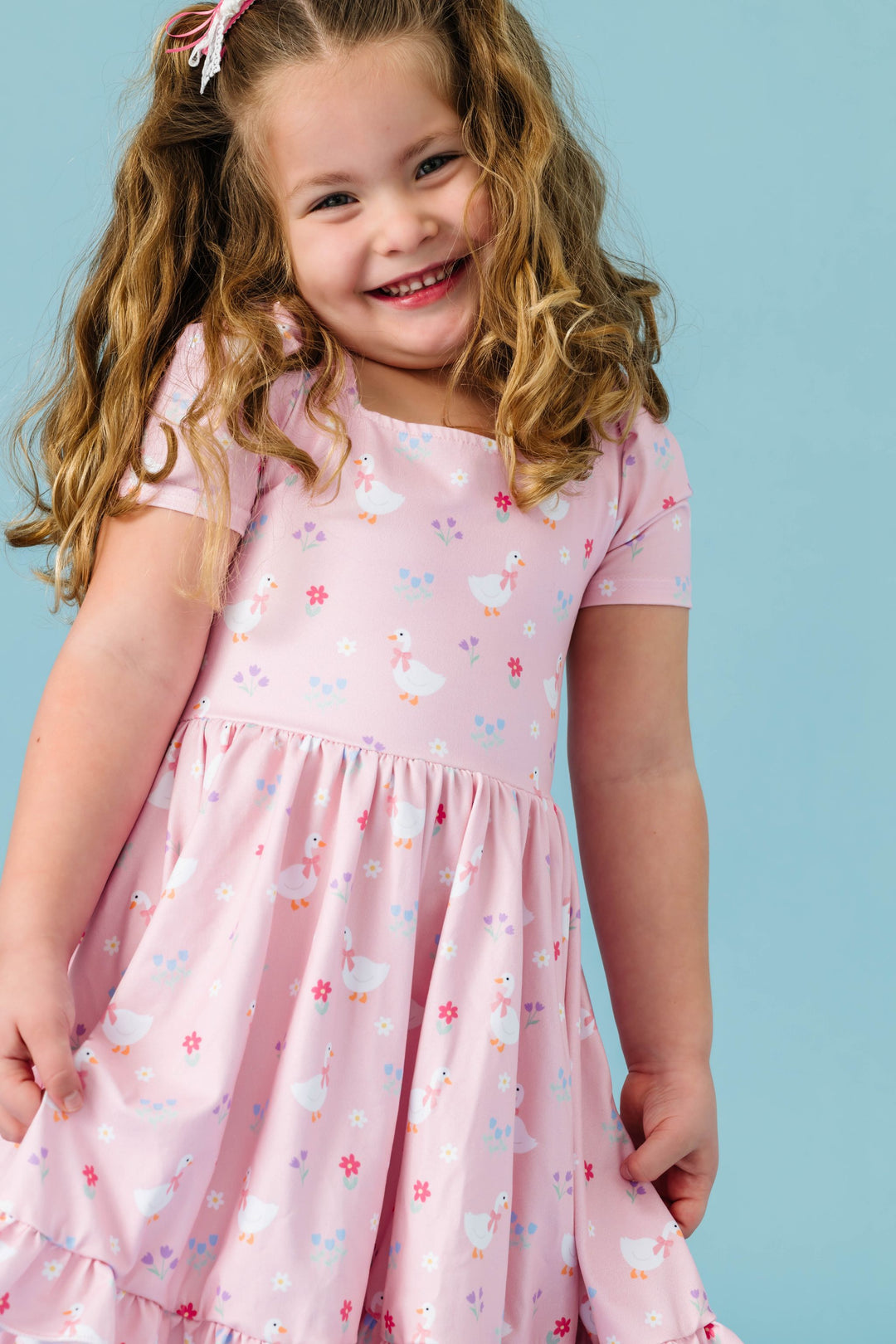 little girl wearing pastel pink twirl dress with goose and flower print for Easter