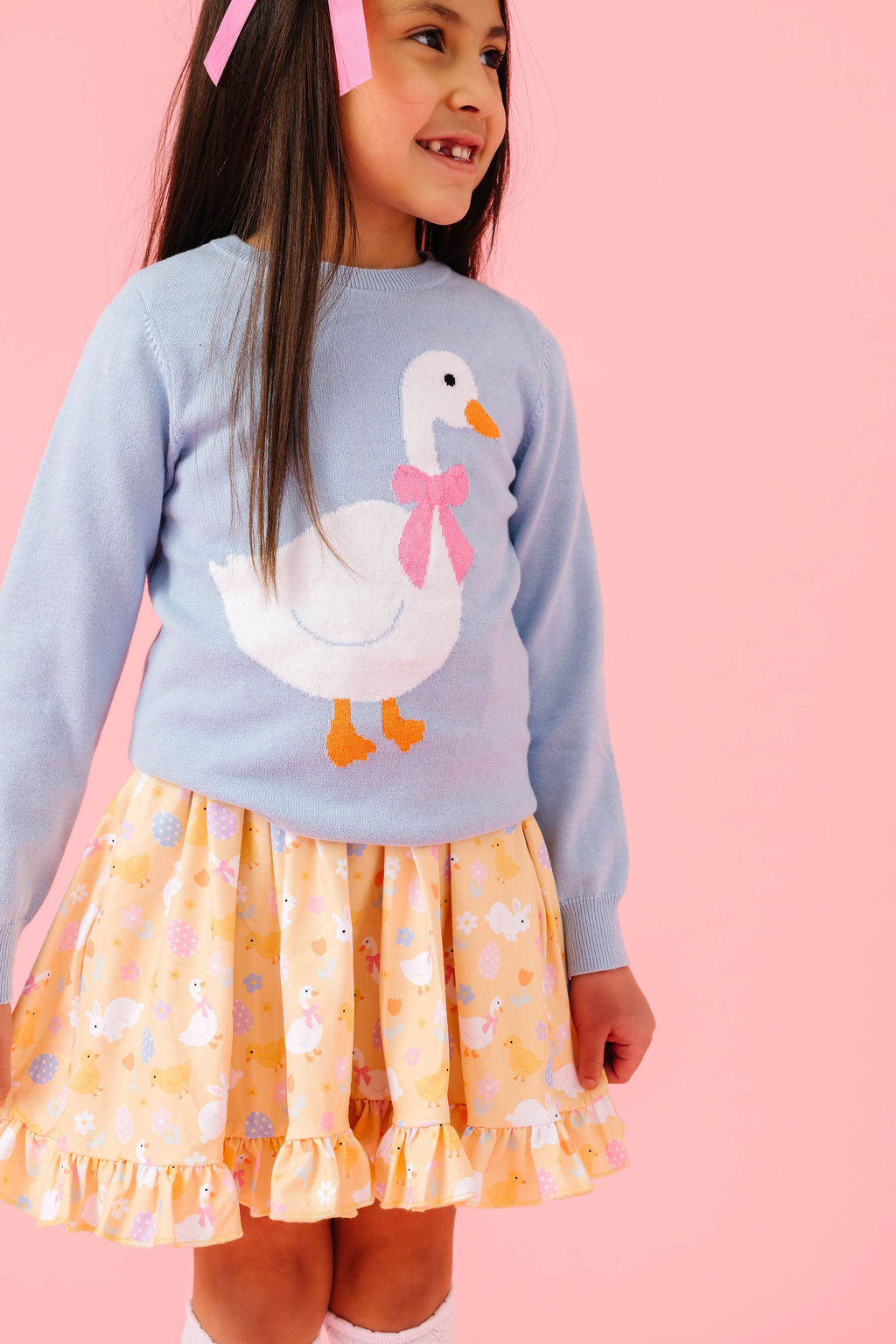 girl wearing a knit sweater with a goose and matching easter dress