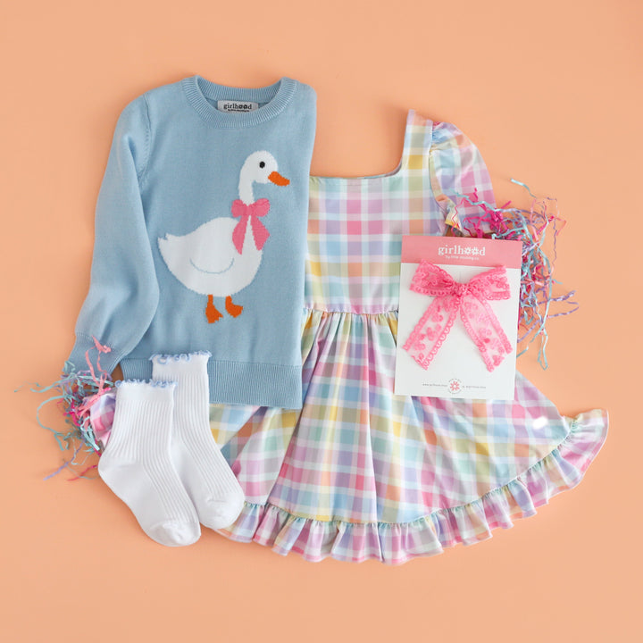 flat lay of light blue cotton knit sweater with goose design paired with spring gingham twirl dress, white ribbed midi socks with blue trim and pink lace bow  for Easter