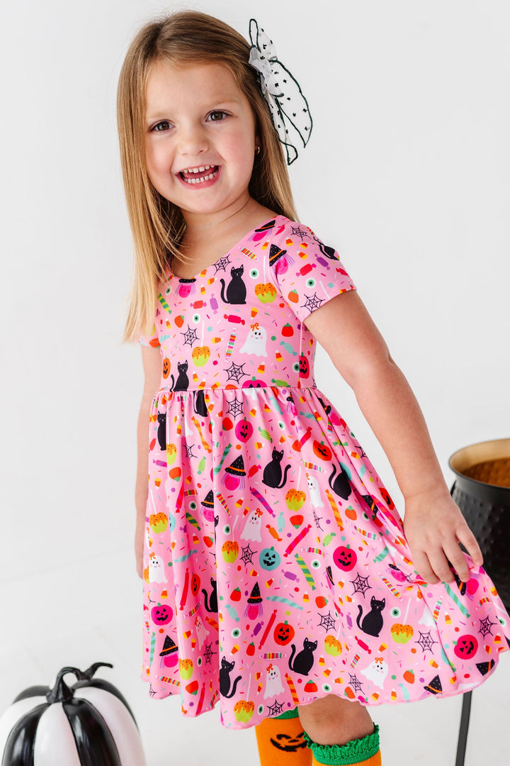 girl wearing pink halloween party print dress
