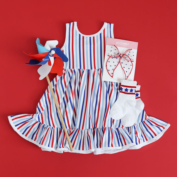 styled 4th of july outfit with girls red, white and blue striped tank top dress with matkcing sheer lace red, white and blue hair bow and star socks