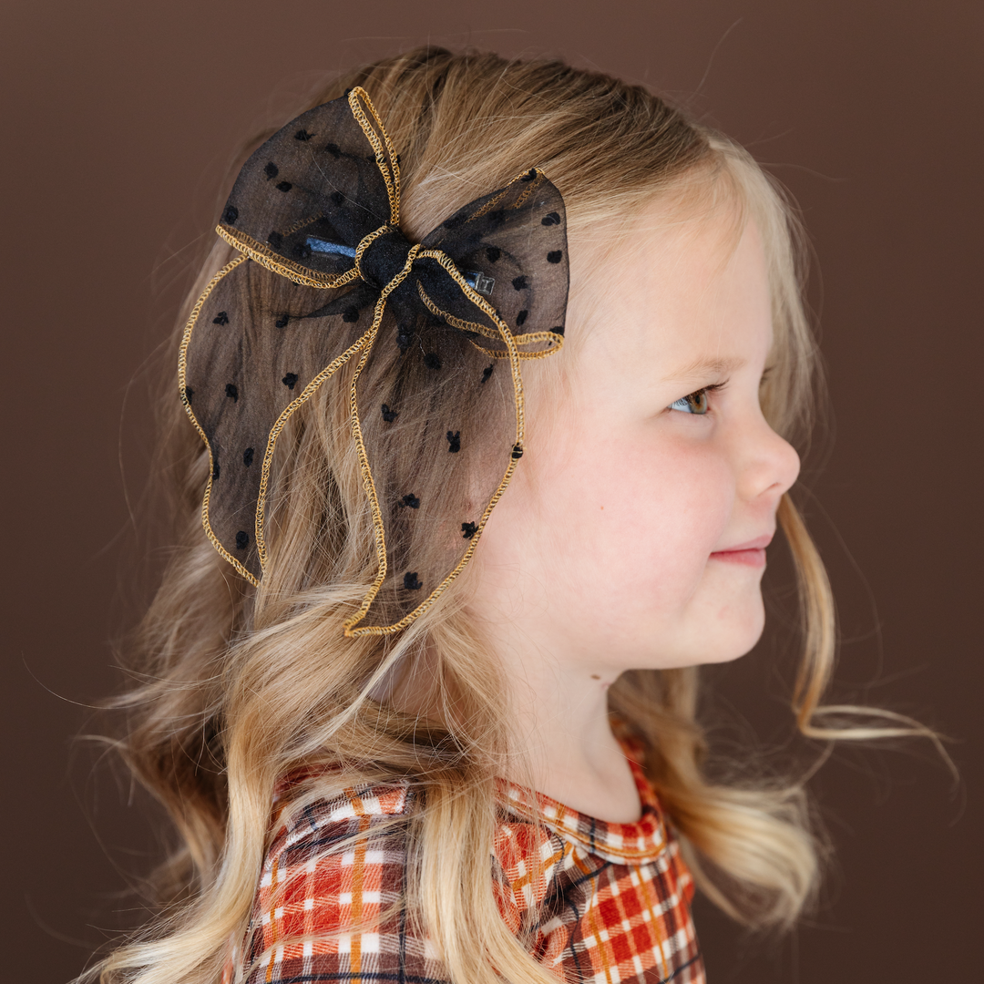 little girl with harvest outfit and black sheer dot bow with gold edging 