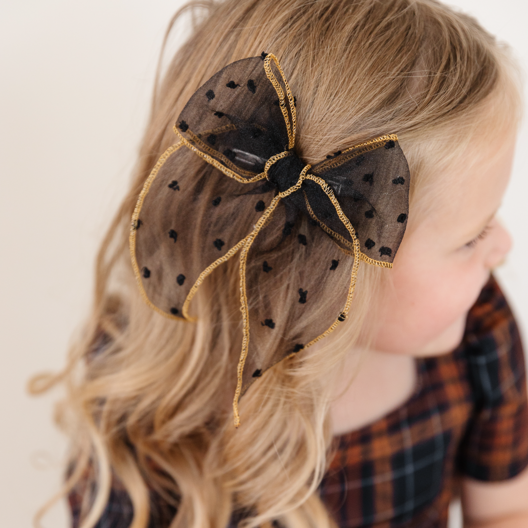 little girl with harvest outfit and black sheer dot bow with gold edging 