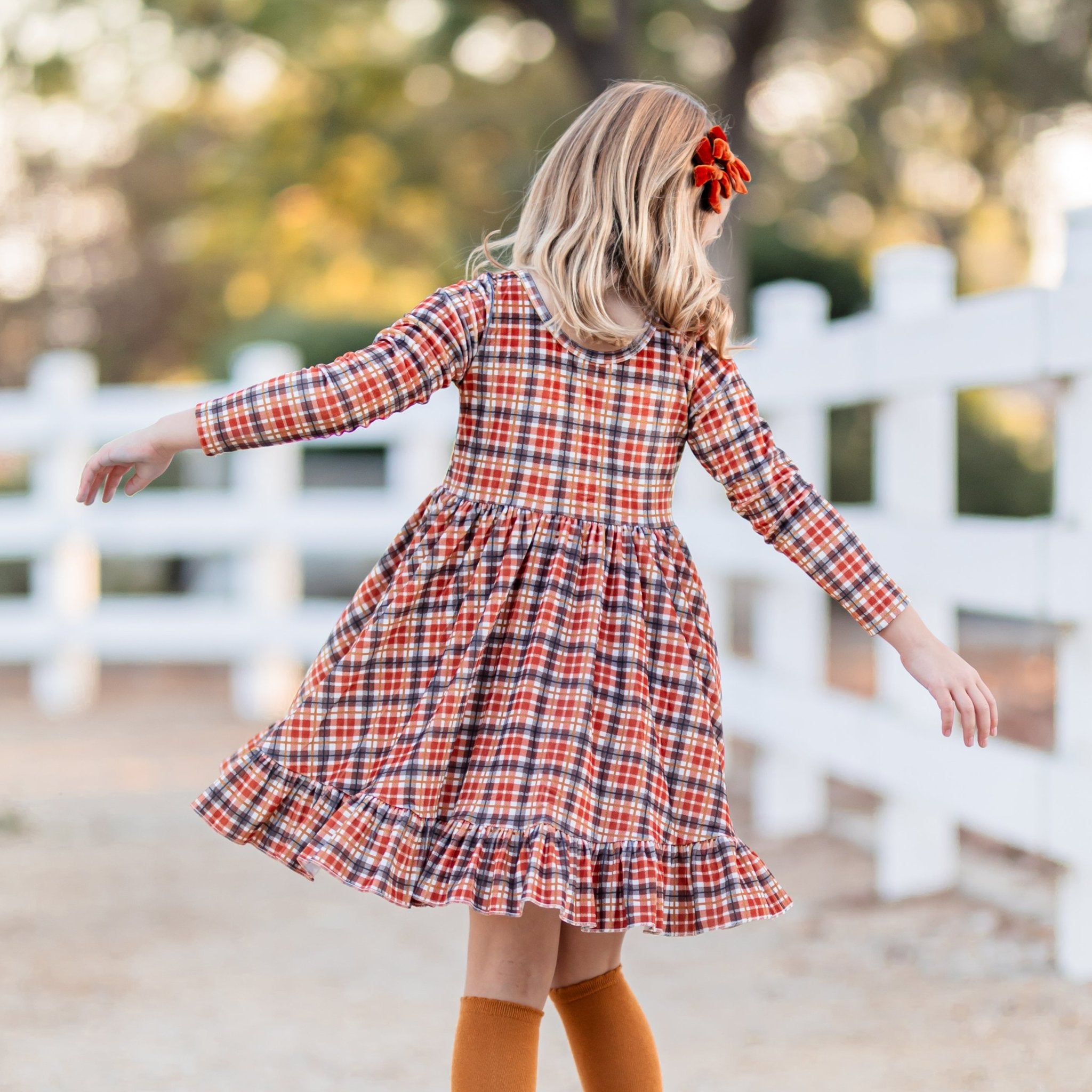 girl in velvet plaid harvest dress in fall colors with matching mustard knee highs and burnt orange velvet pigtail bows