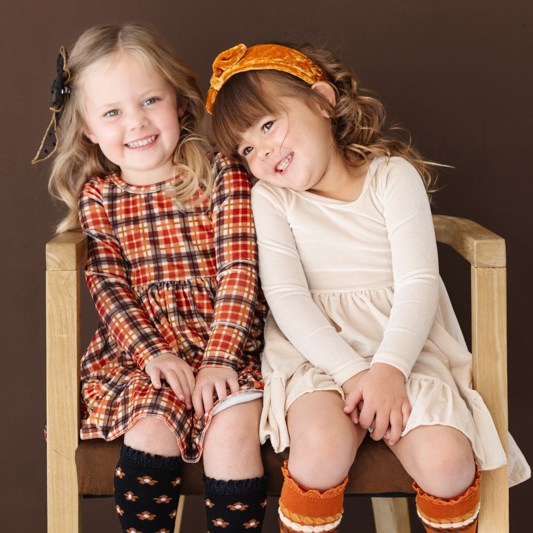 little girls in coordinating long sleeve velvet twirl dresses and matching accessories for Thanksgiving 