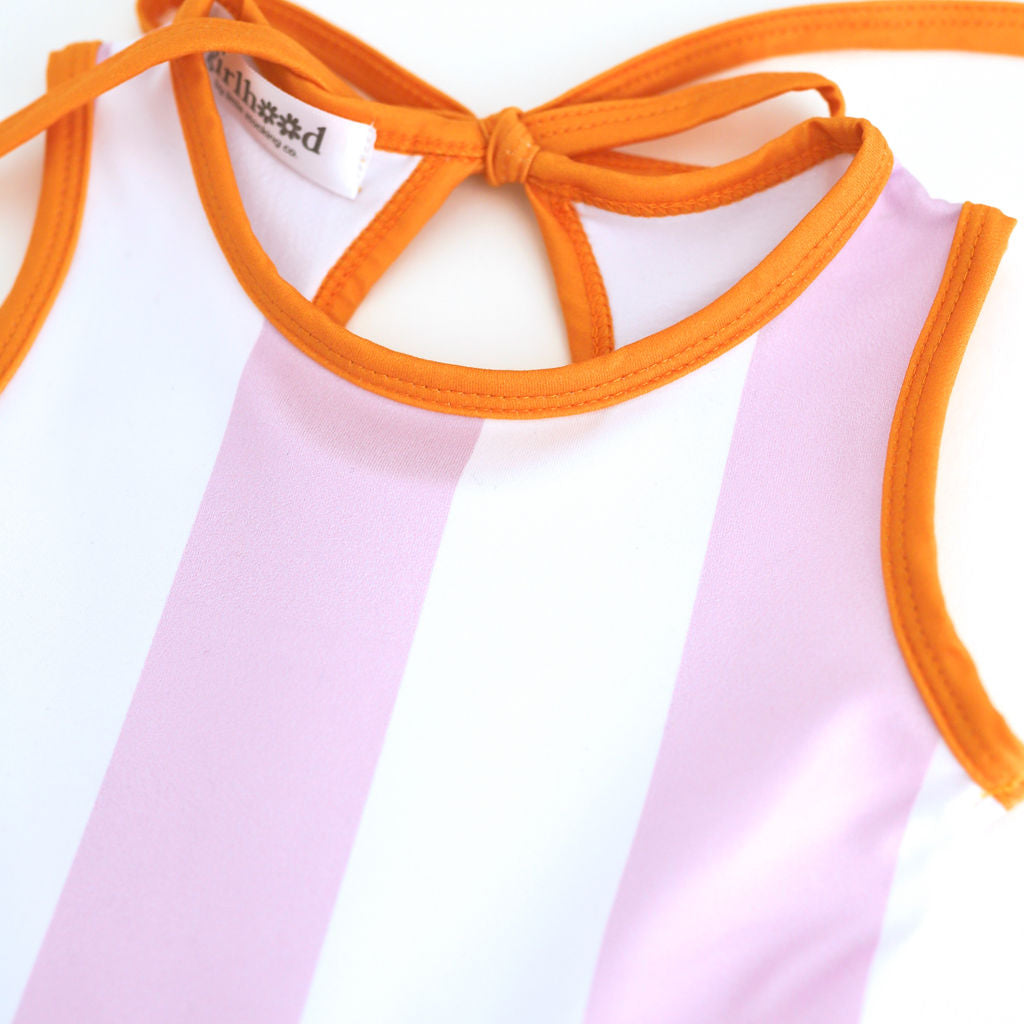 close up of purple and white wide striped twirl dress print with orange binding