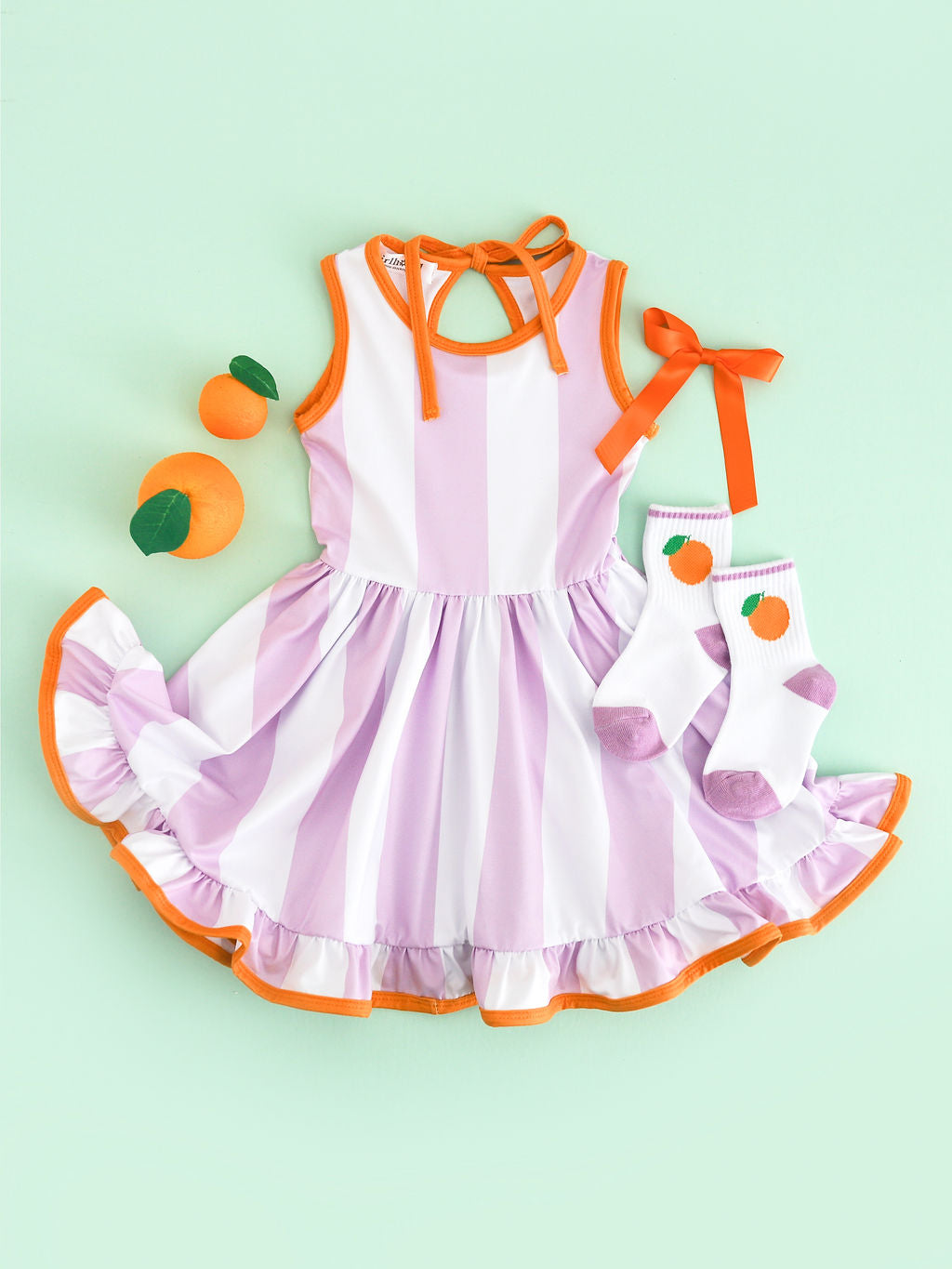 girls' lavender and white wide vertical striped summer twirl with orange trim styled with orange crew socks and orange satin bow