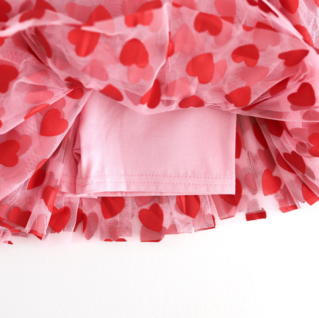 closeup of light pink cotton blend biker shorts attached to pink and red heart print tulle skort