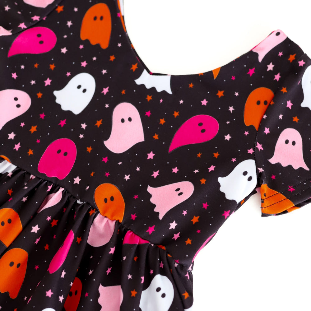 detail photo of colorful ghost print on black v-neck bodice with pink, orange and white ghosts and tiny stars