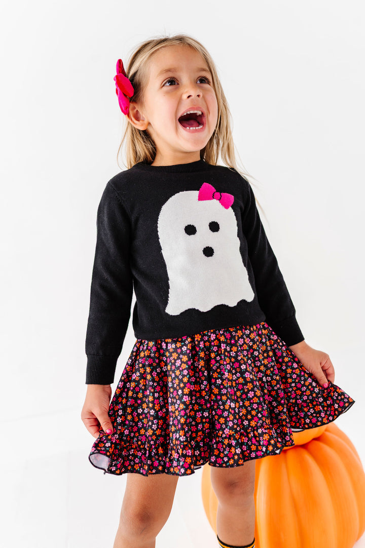 girl wearing ghost sweater over halloween floral print dress