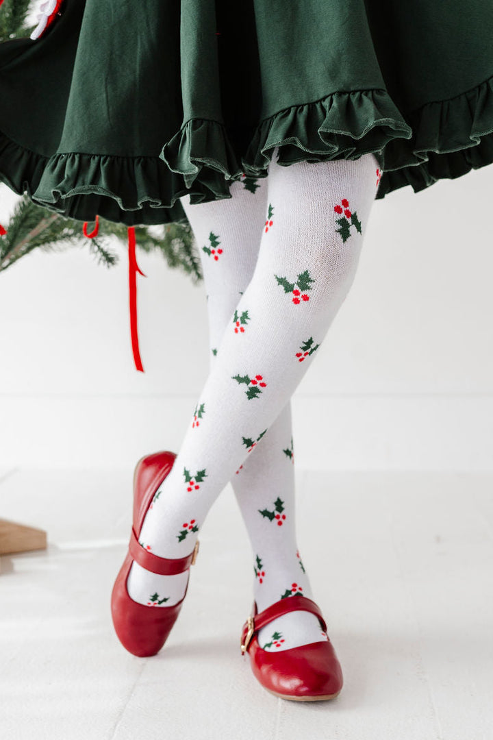 detail photo of girls legs wearing holly knit christmas tights with red t-strap shoes and forest green twirl dress