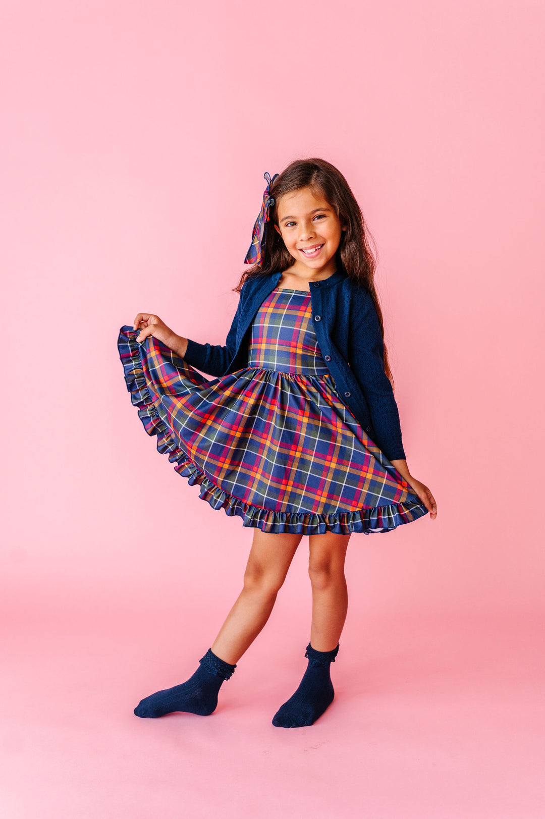 girl wearing navy plaid twirl dress with matching navy sweater and socks