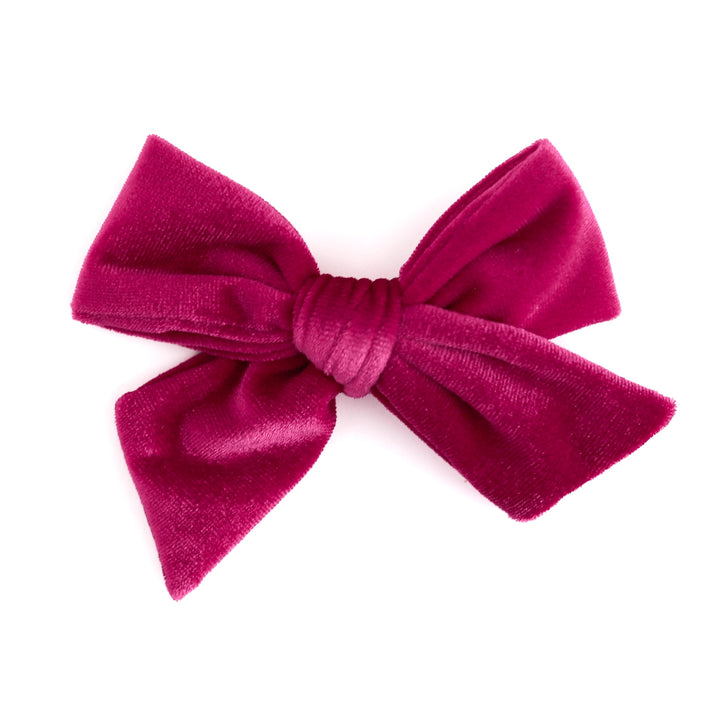 A hot pink velvet hair bow with a textured plush fabric, photographed against a solid white background.