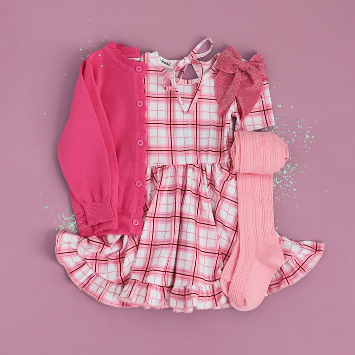 flatlay outfit image of hot pink cardigan sweater and valentines plaid dress