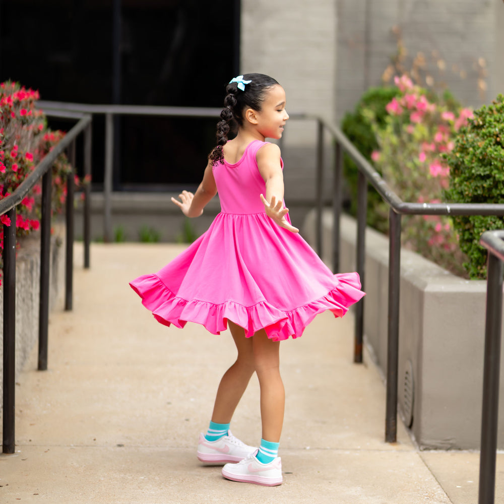 little girl twirling in hot pink sleeveless summer dress
