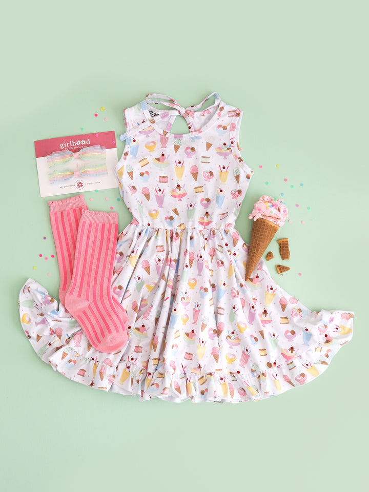 sleeveless twirl dress in white with pastel ice cream print and matching pink striped knee highs and pastel pigtail bows