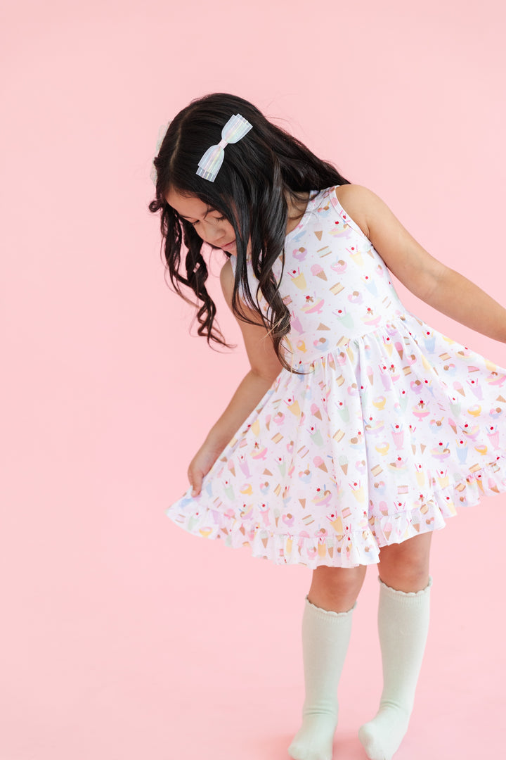 girl in sleeveless twirl dress in white with pastel ice cream print and matching mint scallop edge knee highs